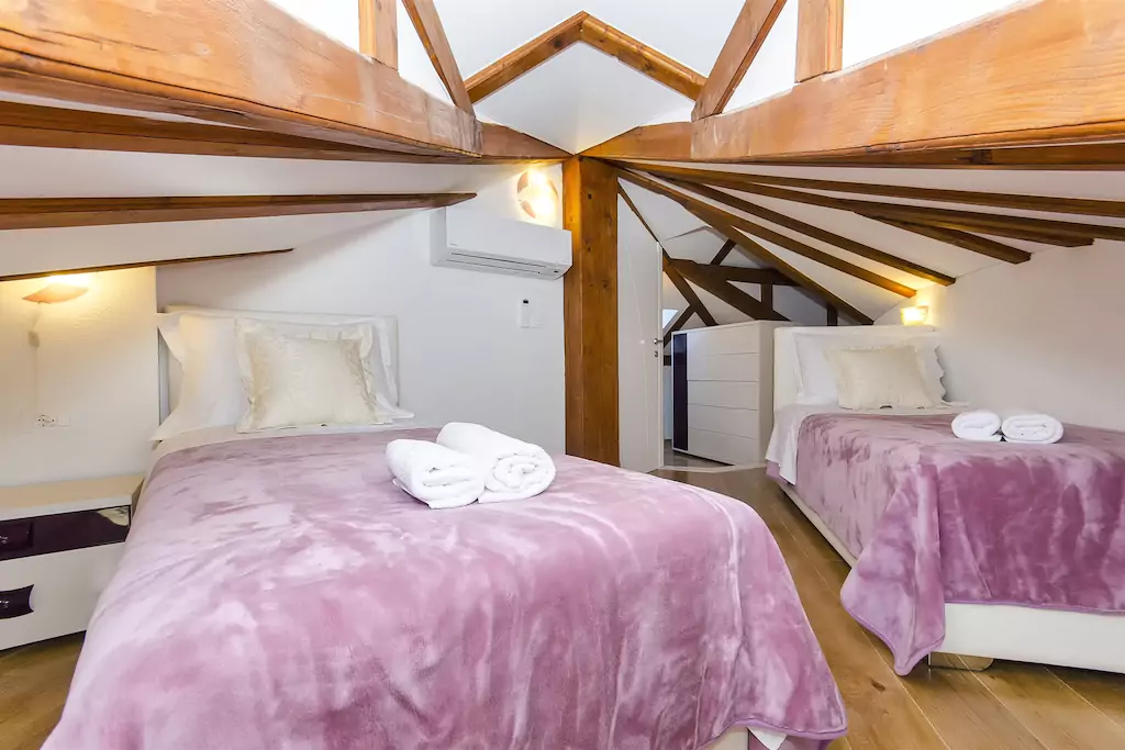 Schlafzimmer 15 m² (Dachhöhe 220 cm am höchsten Punkt), zwei Single-Betten 200 x 90 cm + Sat-TV + WiFi, Kleiderscschrank + Klimaanlage mit DorfBlick.