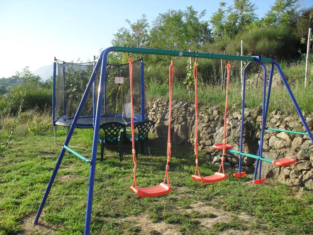 Es gibt eine Rutsche und Schaukeln für Kinder